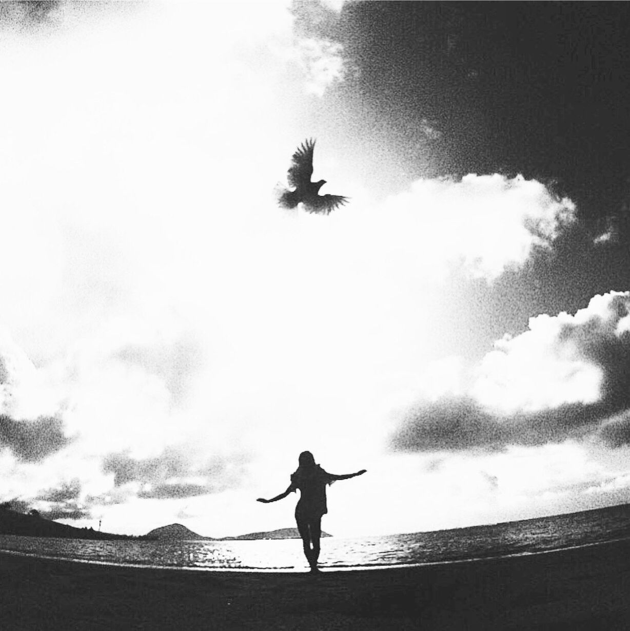 LOW ANGLE VIEW OF SILHOUETTE MAN STANDING ON MOUNTAIN AGAINST SKY