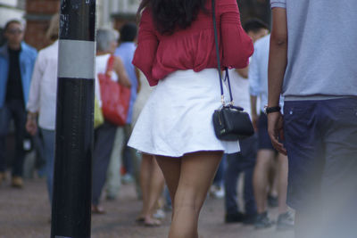 Midsection of man and woman walking on street