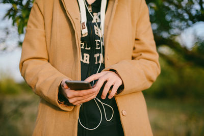 Midsection of man using mobile phone