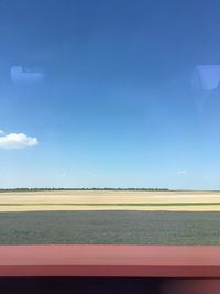 Scenic view of field against blue sky