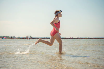 Full length of woman at beach against sky