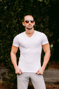 Portrait of man wearing sunglasses standing in park