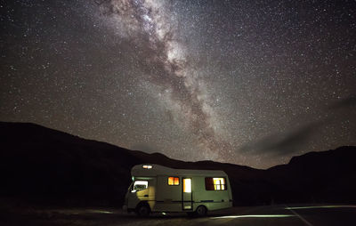 Cars on road against sky at night