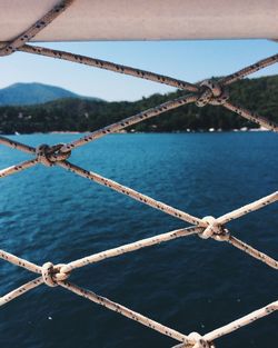 Close-up of bridge over sea against sky