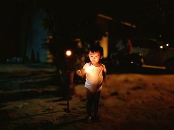 Girl looking at sparkler in night