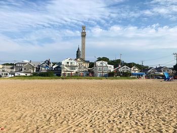 Provincetown, ma seen from the shore of cape cod bay.  pilgrim monument rising in background.
