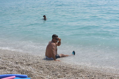 Full length of shirtless man in sea