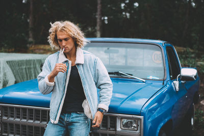 Mid adult man standing in car