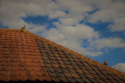 Low angle view of brick wall against cloudy sky