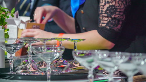 Midsection of woman with drink on table