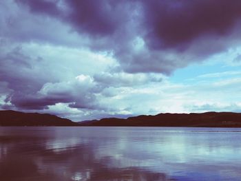 Scenic view of lake against cloudy sky
