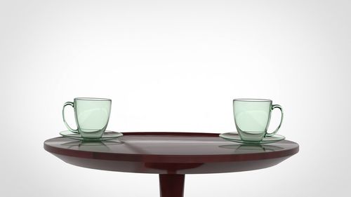 Close-up of empty glass on table against white background