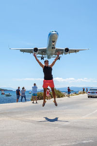 People with airplane flying in sky