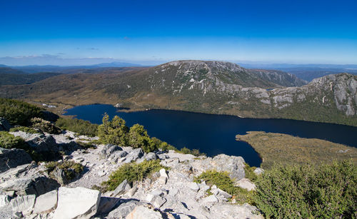 Scenic view of lake and mountains against blue sky