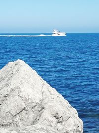 Sailboat sailing in sea against clear sky