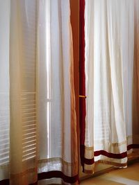 Close-up of white curtains hanging by window