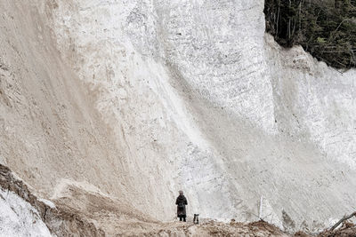 Rear view of men standing on rock