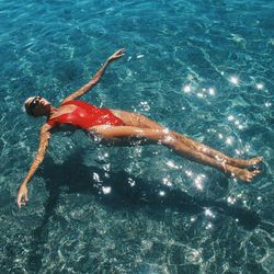 High angle view of woman in sunglasses relaxing in water