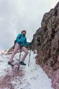 Low angle view of man standing on snow covered mountain