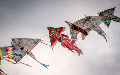 Low angle view of kites flying in sky