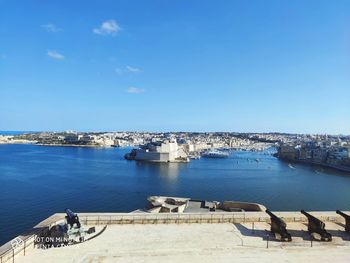 High angle view of harbor by sea against blue sky