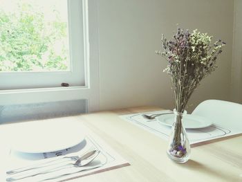 Vase and plates on dinning table at home