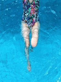 Low section of woman swimming in pool