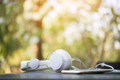 Close-up of mobile phone with headphones on table