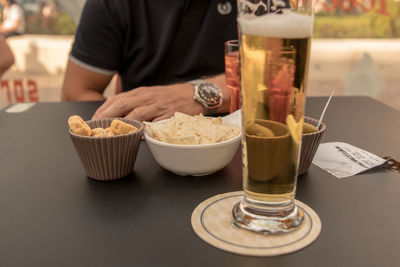 Midsection of woman holding drink on table