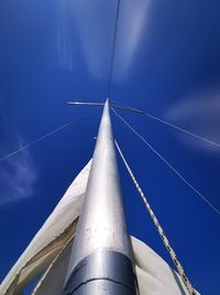 Low angle view of sailboat against blue sky