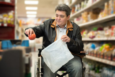 A disabled person in a wheelchair buys groceries