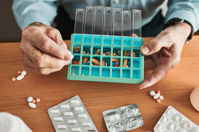 Senior man organizing his medication into pill dispenser. senior man taking pills from box