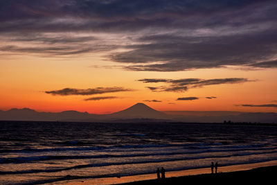 Scenic view of sea against dramatic sky during sunset