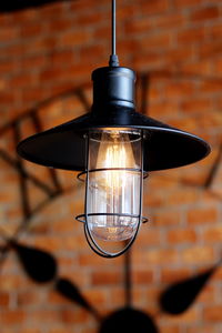 Low angle view of light bulb hanging on wall