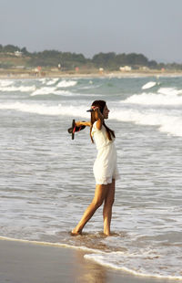 Rear view of woman standing on beach