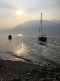 Sailboat sailing on sea against sky during sunset