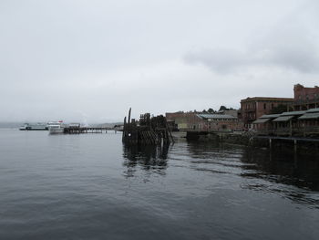 Scenic view of sea by buildings against sky