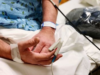 Midsection of man sitting at hospital