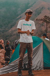 Full length of young man standing against mountain