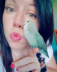 Close-up portrait of woman holding bird