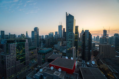 Aerial view of buildings in city against sky during sunset