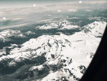 Aerial view of snowcapped mountains against sky