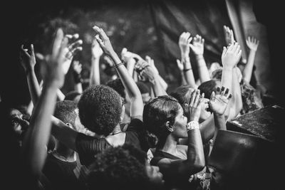 Audience enjoying with arms raised during concert