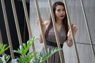 Portrait of woman standing by railing