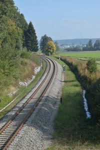 Railroad tracks amidst trees against sky