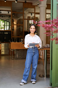 Portrait of young woman standing in city