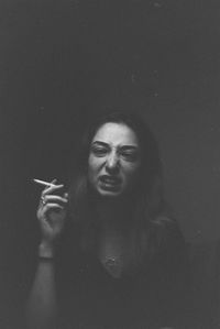 Portrait of a young woman holding cigarette