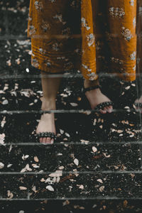 Low section of woman standing on railroad tracks