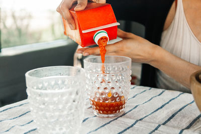 Close-up of hand pouring tea cup on table