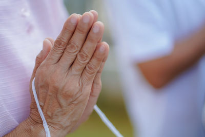 Midsection of man holding thread praying in temple